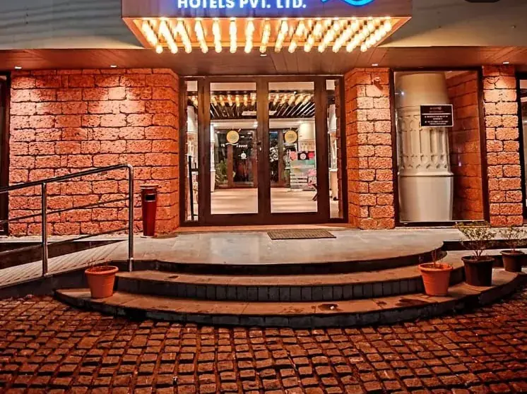 A brick-fronted hotel entrance with steps and warm lighting