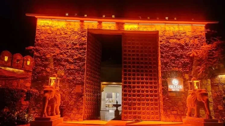 A resort entrance gate lit orange at night
