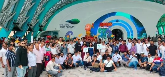 A large corporate group posing outside the Singapore Oceanarium